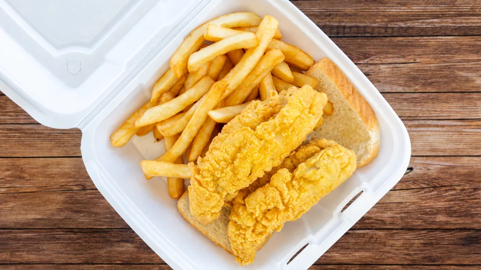 Breaded fish pieces with fries and bread